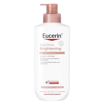 A bottle of Eucerin Spotless Brightening Body Lotion with a white plastic container and a metallic rose gold pump dispenser, shown against a plain white background.
