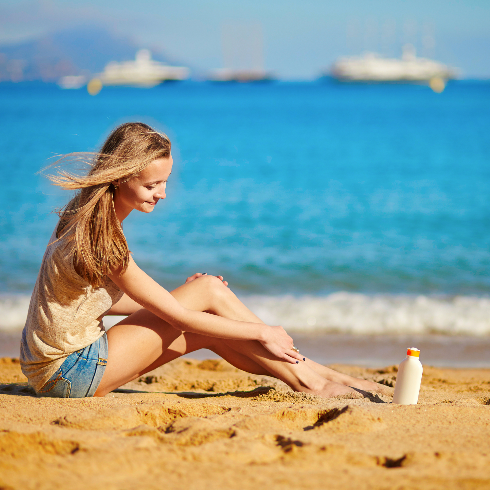 Woman applying sun care skincare products while enjoying time at the beach